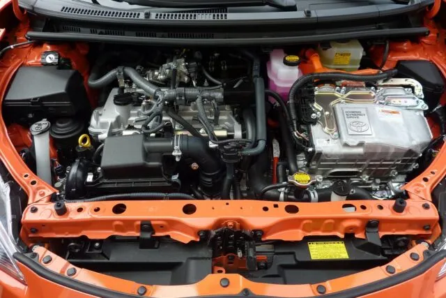 Compartimentul motor al unei mașini deschis, cu bateria în prim-plan